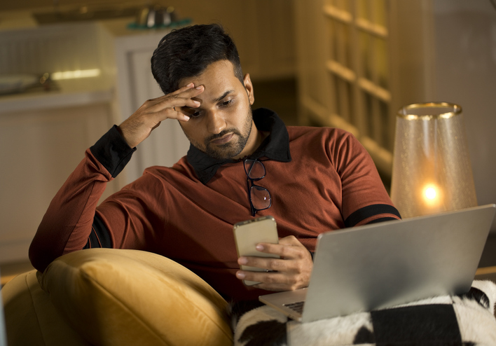 Man stressed looking at phone
